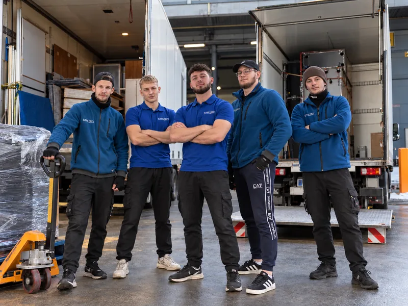 STRUXO GROUP crew – five movers in front of trucks